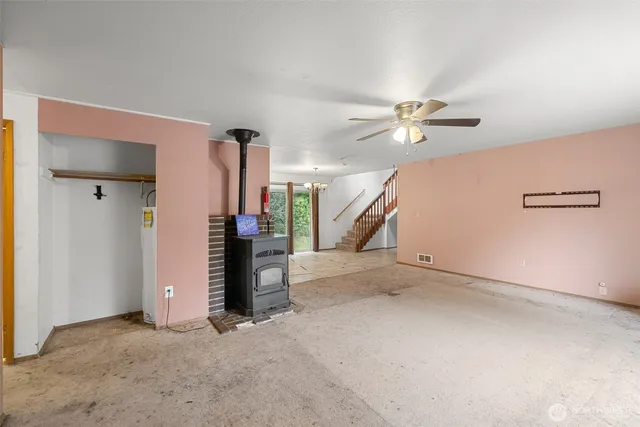 an empty room with a ceiling fan and window