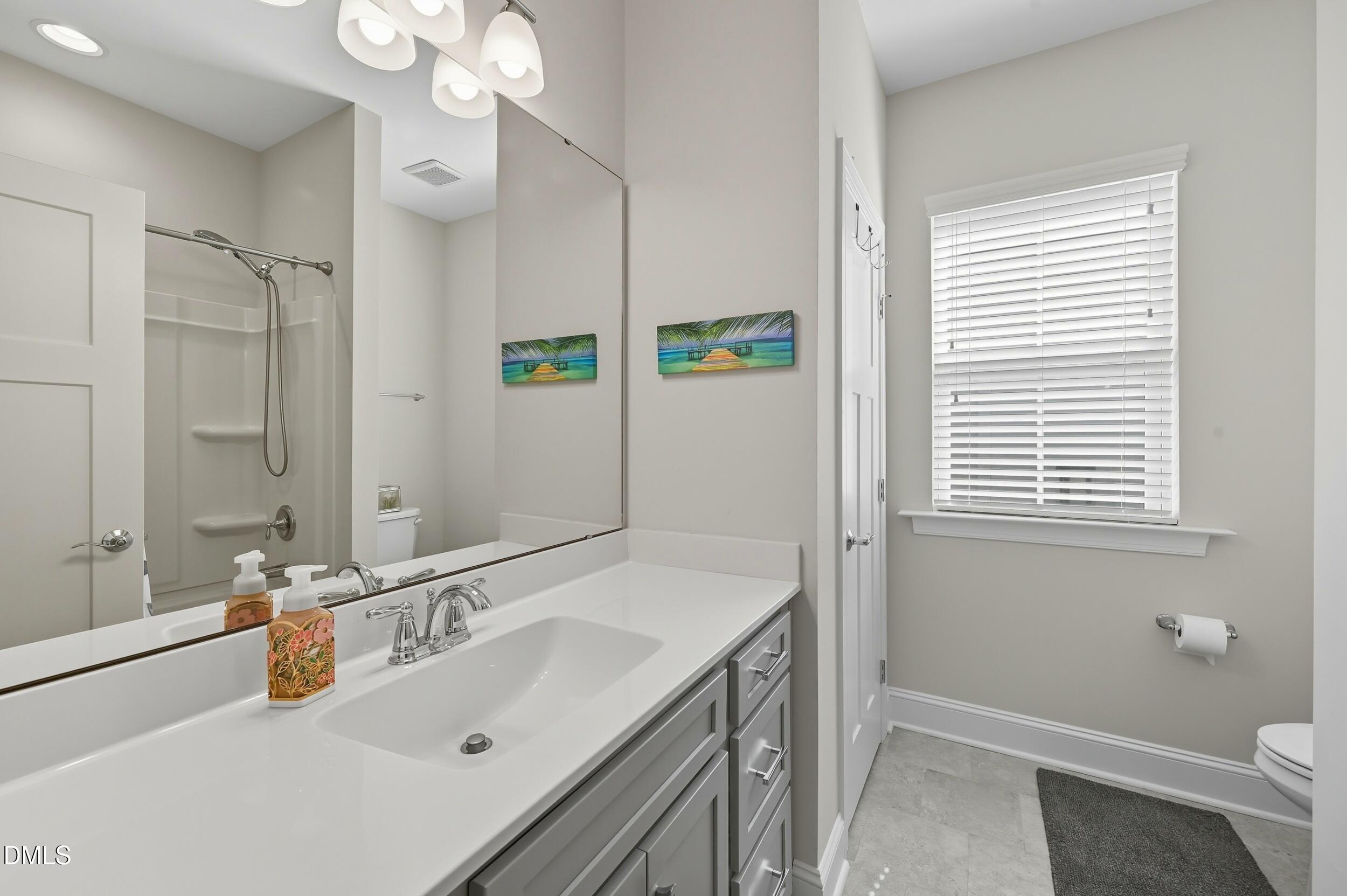 116 Beaufort Loop Clayton, NC 27520 - Photo 21 of 33 a bathroom with a sink double vanity granite tub shower and a mirror