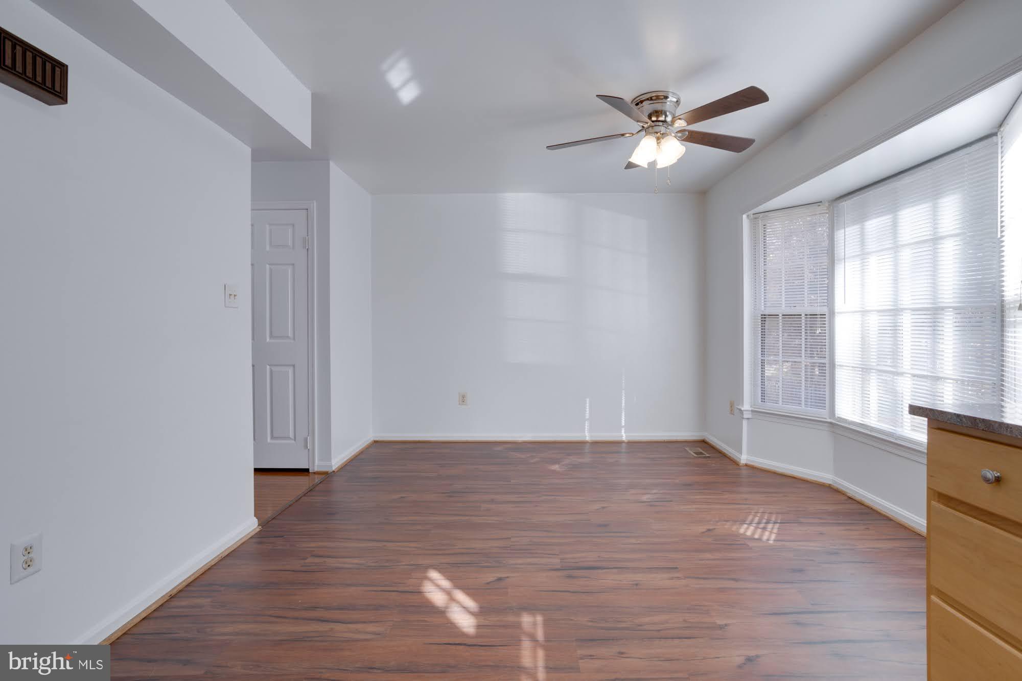 9043 Blarney Stone Drive Springfield, VA 22152 - Photo 12 of 23 a view of an empty room with wooden floor and a window
