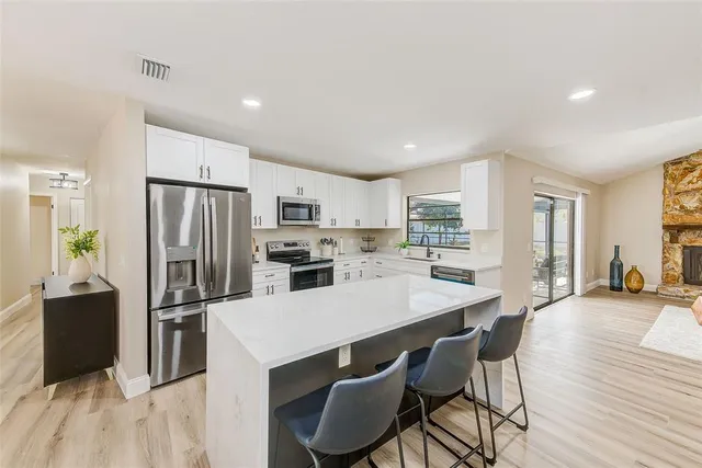 a kitchen with refrigerator a microwave and cabinets