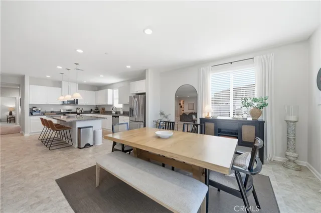 a spacious bedroom with a bed and dresser with mirror
