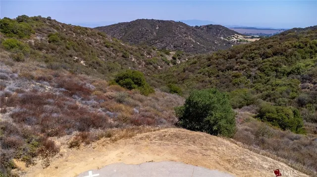 a view of a dry yard with mountains in the background