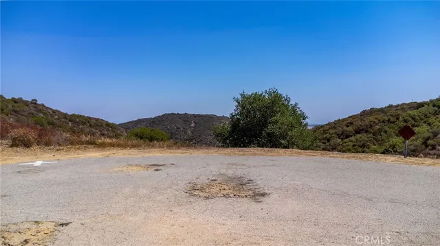 a view of a dry yard with mountains in the background