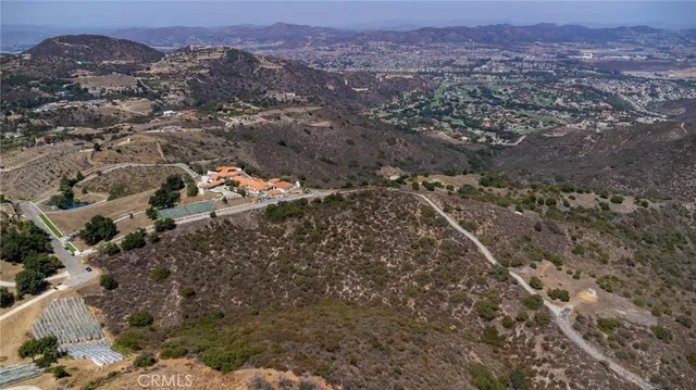an aerial view of house with yard and mountain view in back