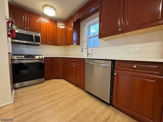 a kitchen with stainless steel appliances granite countertop a stove a sink and a microwave