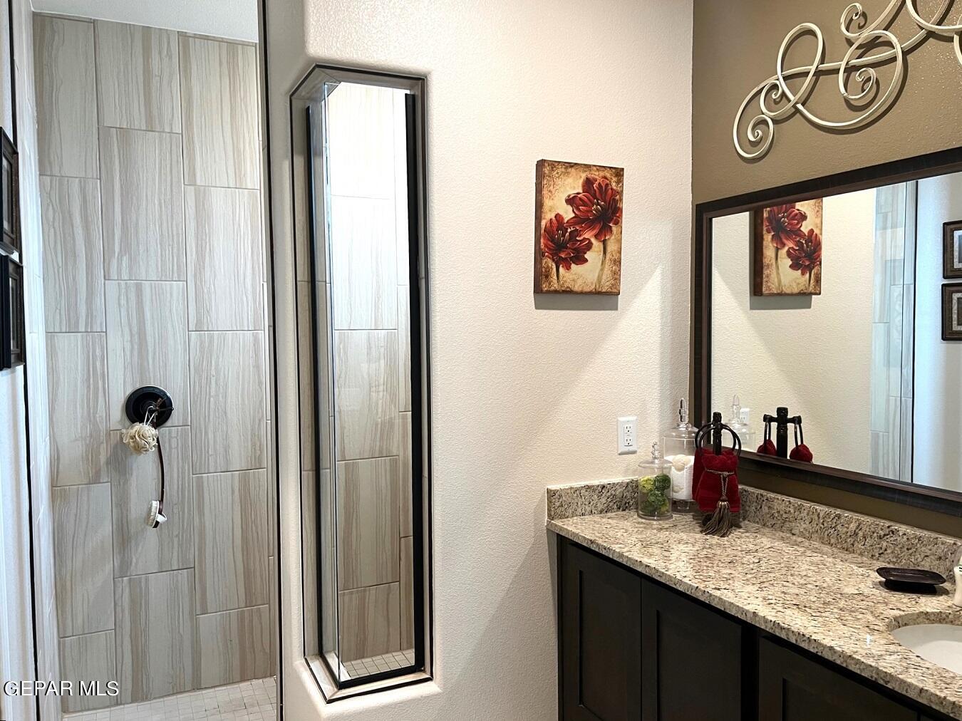 12869 Crystal Downs El Paso, TX 79928 - Photo 14 of 18 a bathroom with a granite countertop sink and a mirror