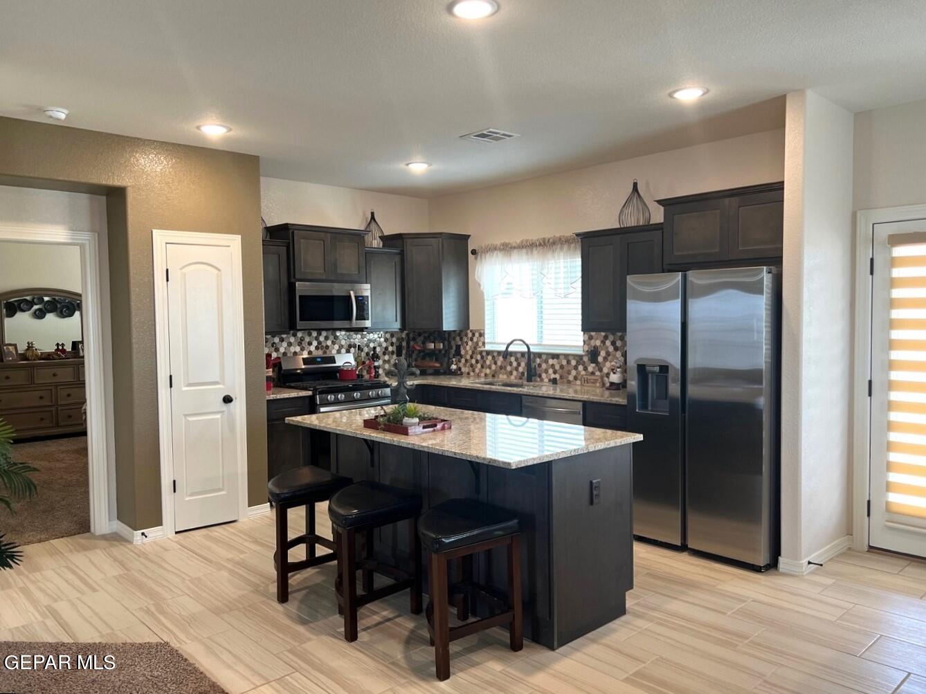 12869 Crystal Downs El Paso, TX 79928 - Photo 5 of 18 a kitchen with kitchen island granite countertop a sink refrigerator and cabinets