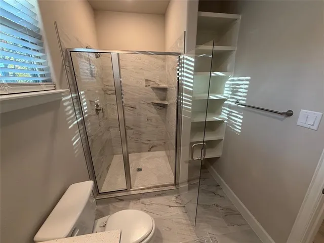 a bathroom with a toilet and a shower