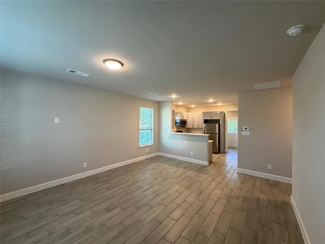 a view of empty room with wooden floor