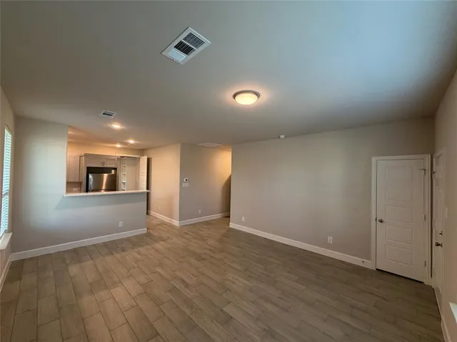 a view of empty room with wooden floor