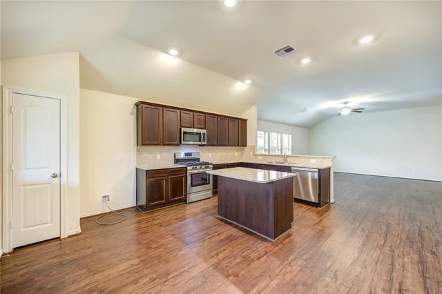 a kitchen with stainless steel appliances granite countertop a stove a sink and a microwave