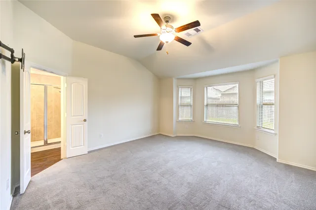 an empty room with windows and fan