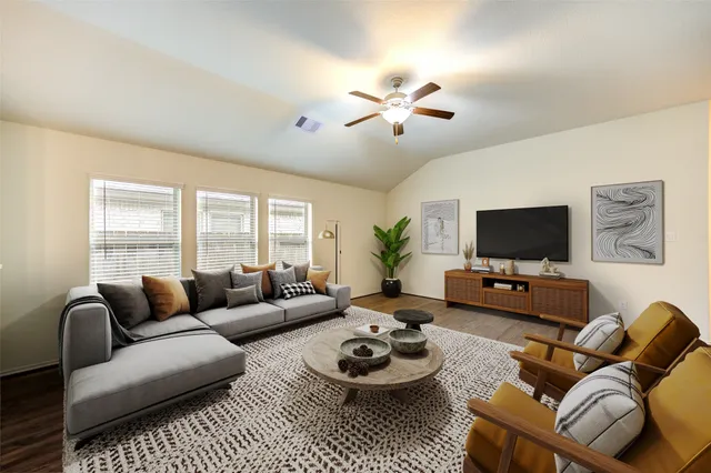 a living room with furniture a flat screen tv and a large window