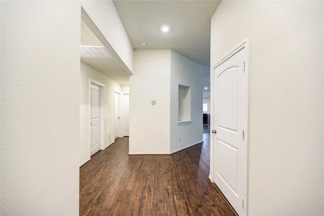 a view of a hallway with wooden floor