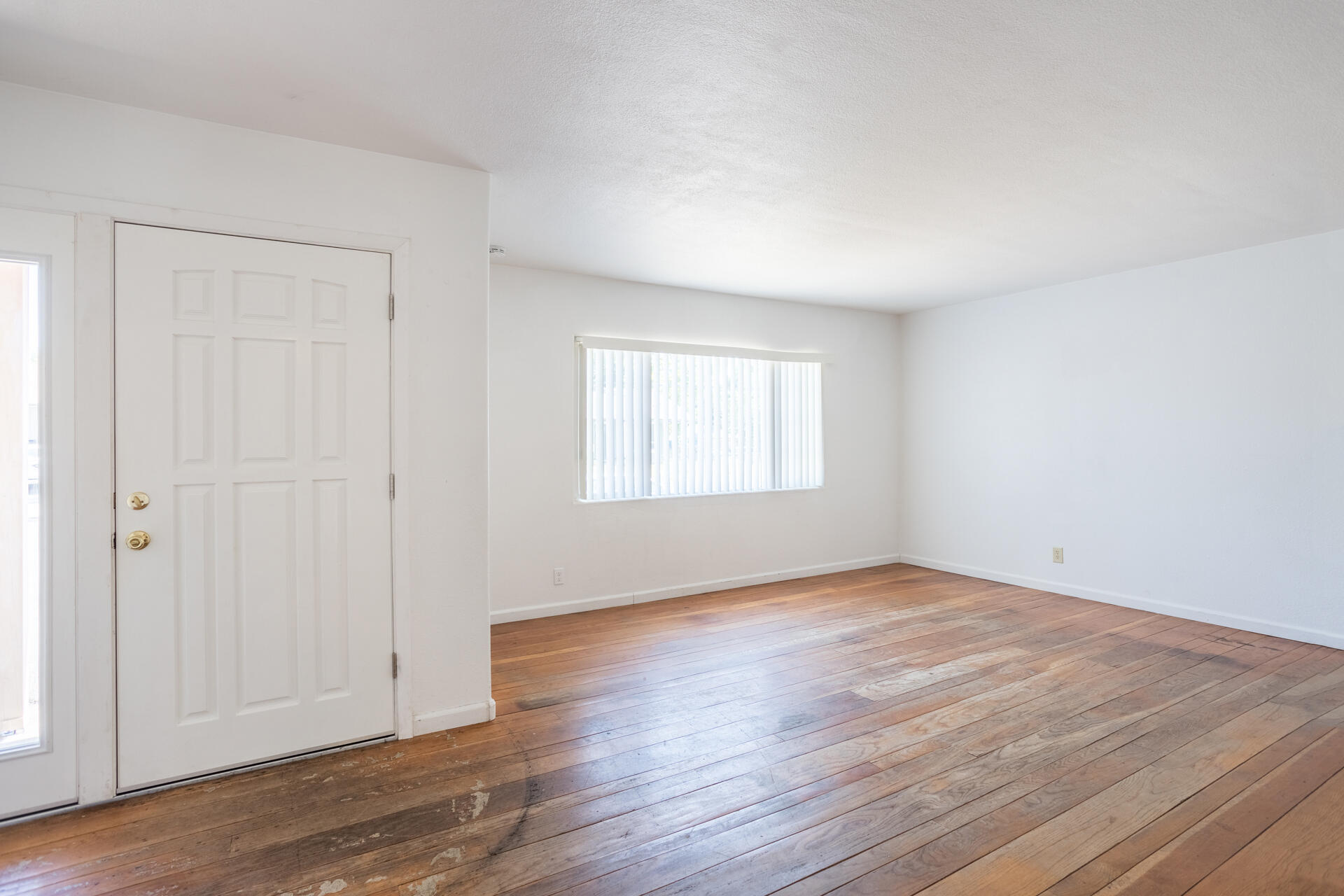 1105 5th Street Redding, CA 96002 - Photo 2 of 11 a view of an empty room with wooden floor and a window