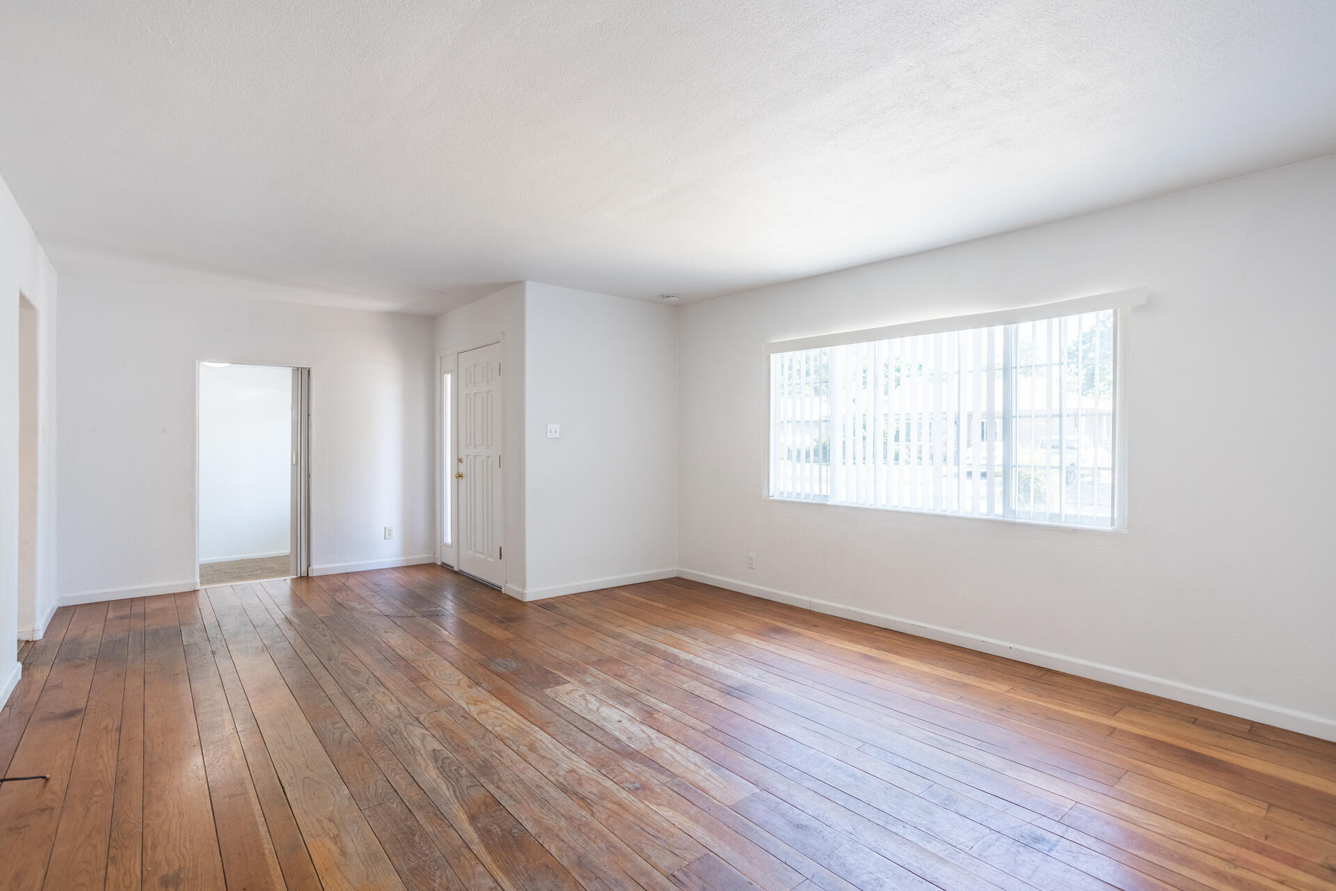 1105 5th Street Redding, CA 96002 - Photo 3 of 11 an empty room with wooden floor and windows