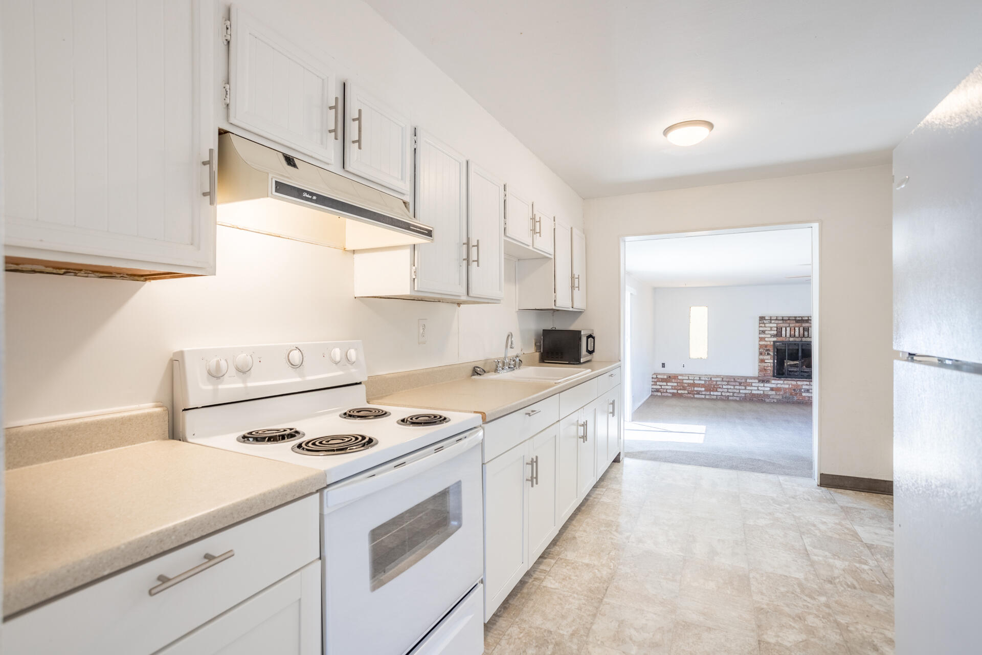 1105 5th Street Redding, CA 96002 - Photo 5 of 11 a kitchen with a stove a sink and a refrigerator