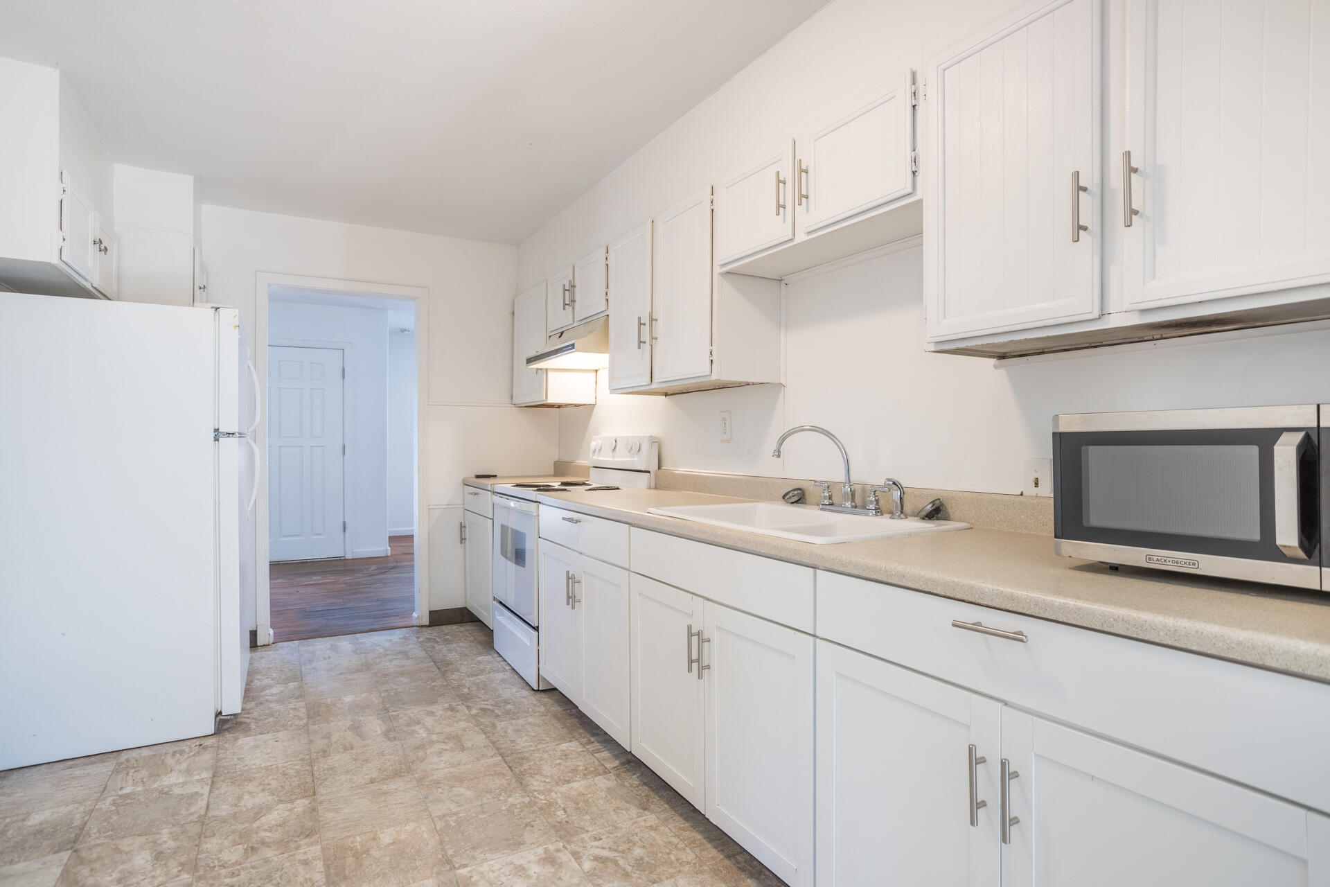 1105 5th Street Redding, CA 96002 - Photo 6 of 11 a kitchen with granite countertop white cabinets and white appliances