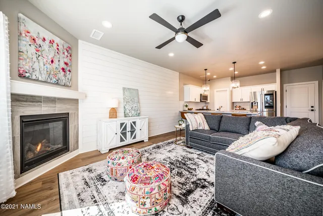 a kitchen with stainless steel appliances a dining table chairs refrigerator and sink