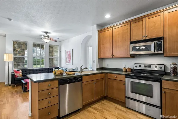 a kitchen with stainless steel appliances granite countertop a refrigerator stove top oven a sink and dishwasher