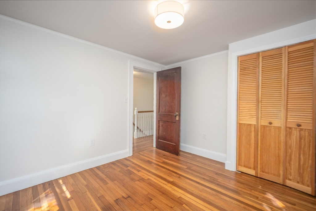 10 Weston Street Milton, MA 02186 - Photo 19 of 35 an empty room with wooden floor and windows
