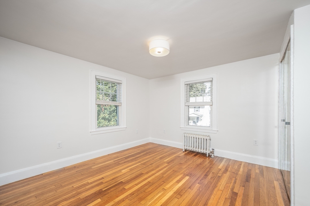 10 Weston Street Milton, MA 02186 - Photo 23 of 35 an empty room with wooden floor and windows
