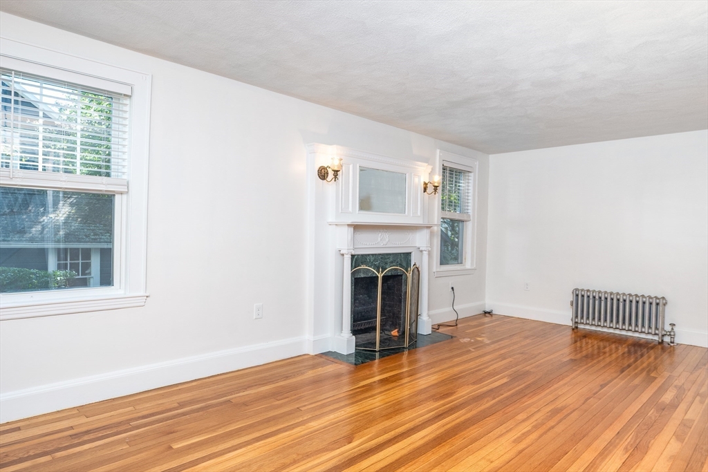 10 Weston Street Milton, MA 02186 - Photo 10 of 35 a view of empty room with wooden floor and fireplace