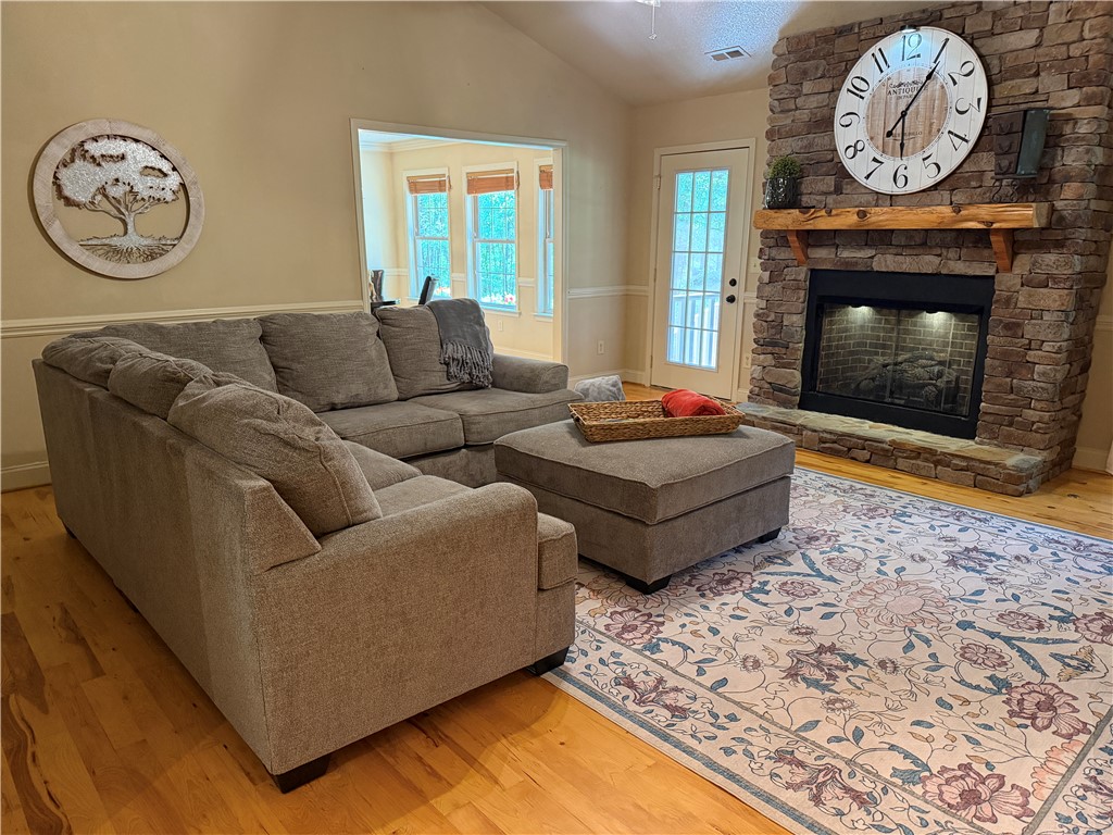 232 Hunters Trail Walhalla, SC 29691 - Photo 10 of 38 This inviting living space features warm wooden floors and a cozy stone fireplace, perfect for relaxation.
