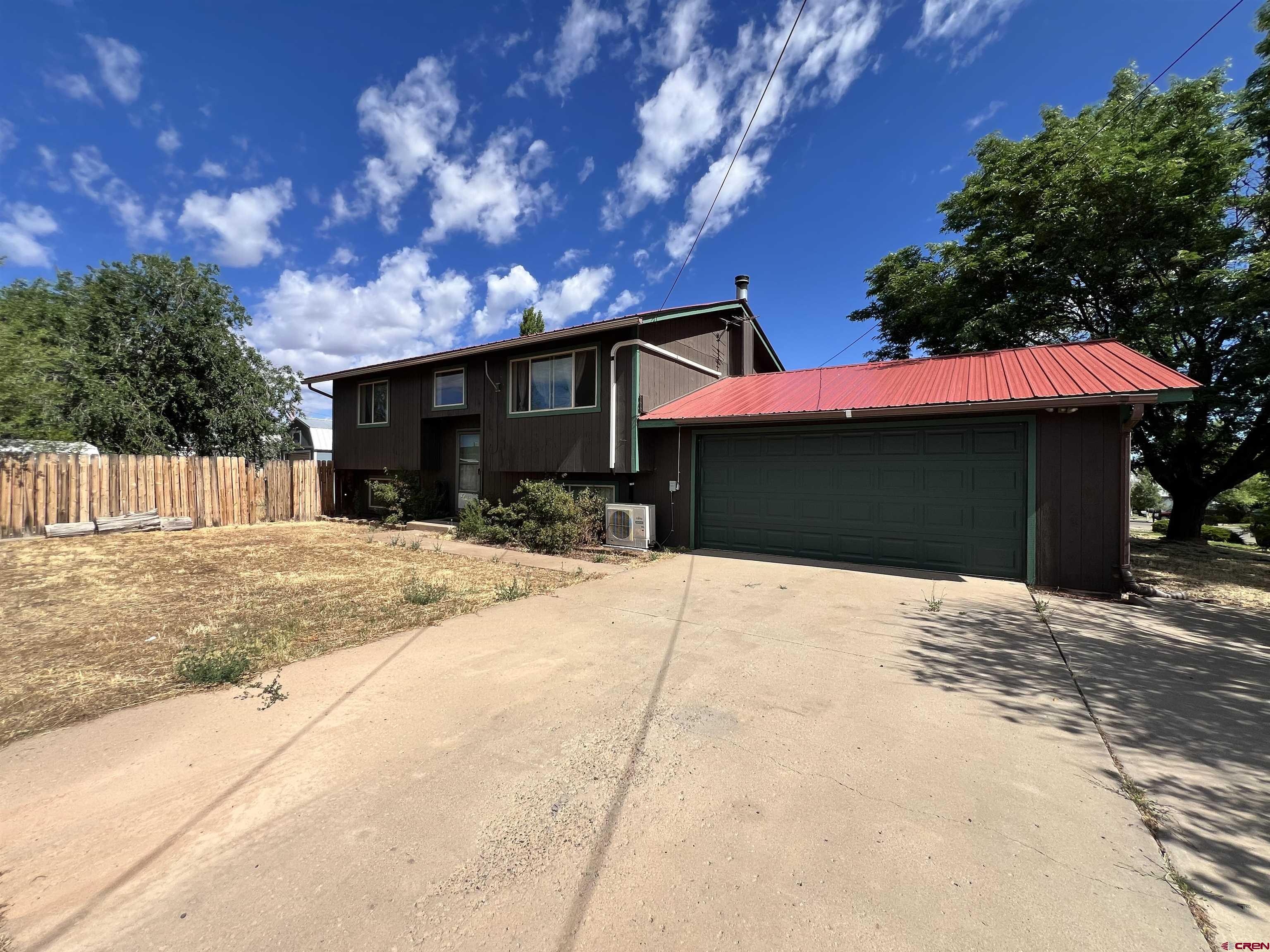 1328 Jackson Street Cortez, CO 81321 - Photo 3 of 37 a front view of a house with a yard and garage