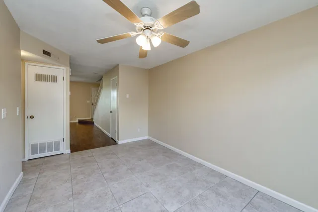an empty room with a chandelier fan and closet