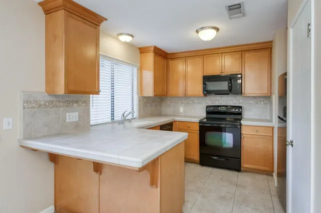 a kitchen with stainless steel appliances a stove sink microwave and cabinets