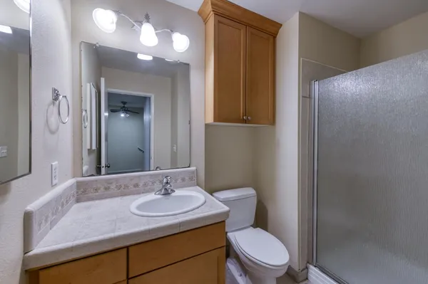 an empty room with windows and fan