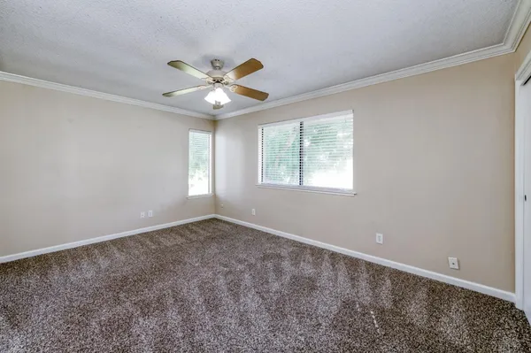 an empty room with a ceiling fan and a window