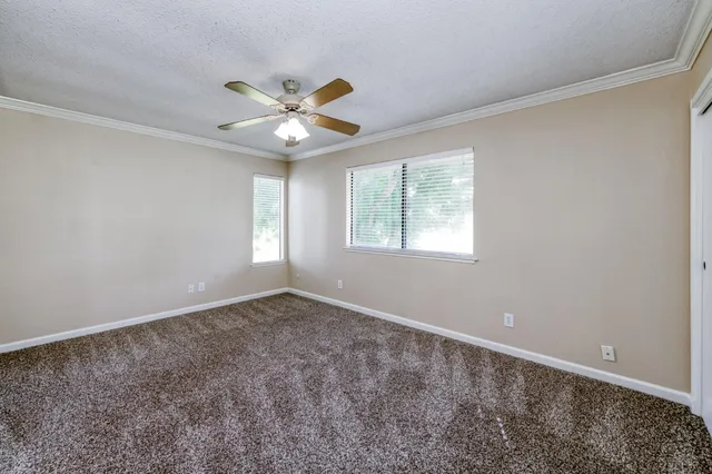 an empty room with a ceiling fan and a window
