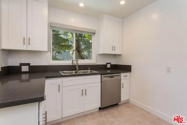 a kitchen with stainless steel appliances granite countertop a sink stove and cabinets