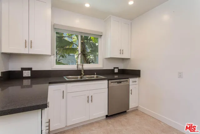 a kitchen with stainless steel appliances granite countertop a sink stove and cabinets