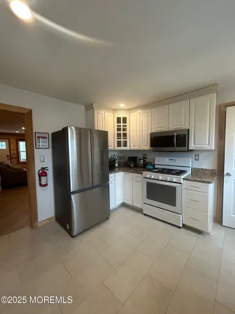 a kitchen with granite countertop a refrigerator stove and microwave