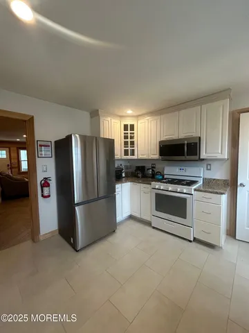 a kitchen with granite countertop a refrigerator stove and microwave