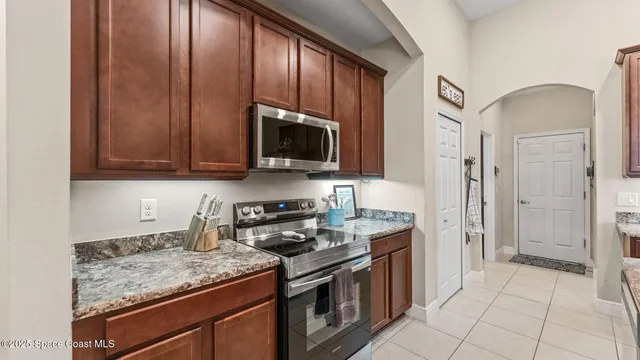 a kitchen with a stove and a view of living room