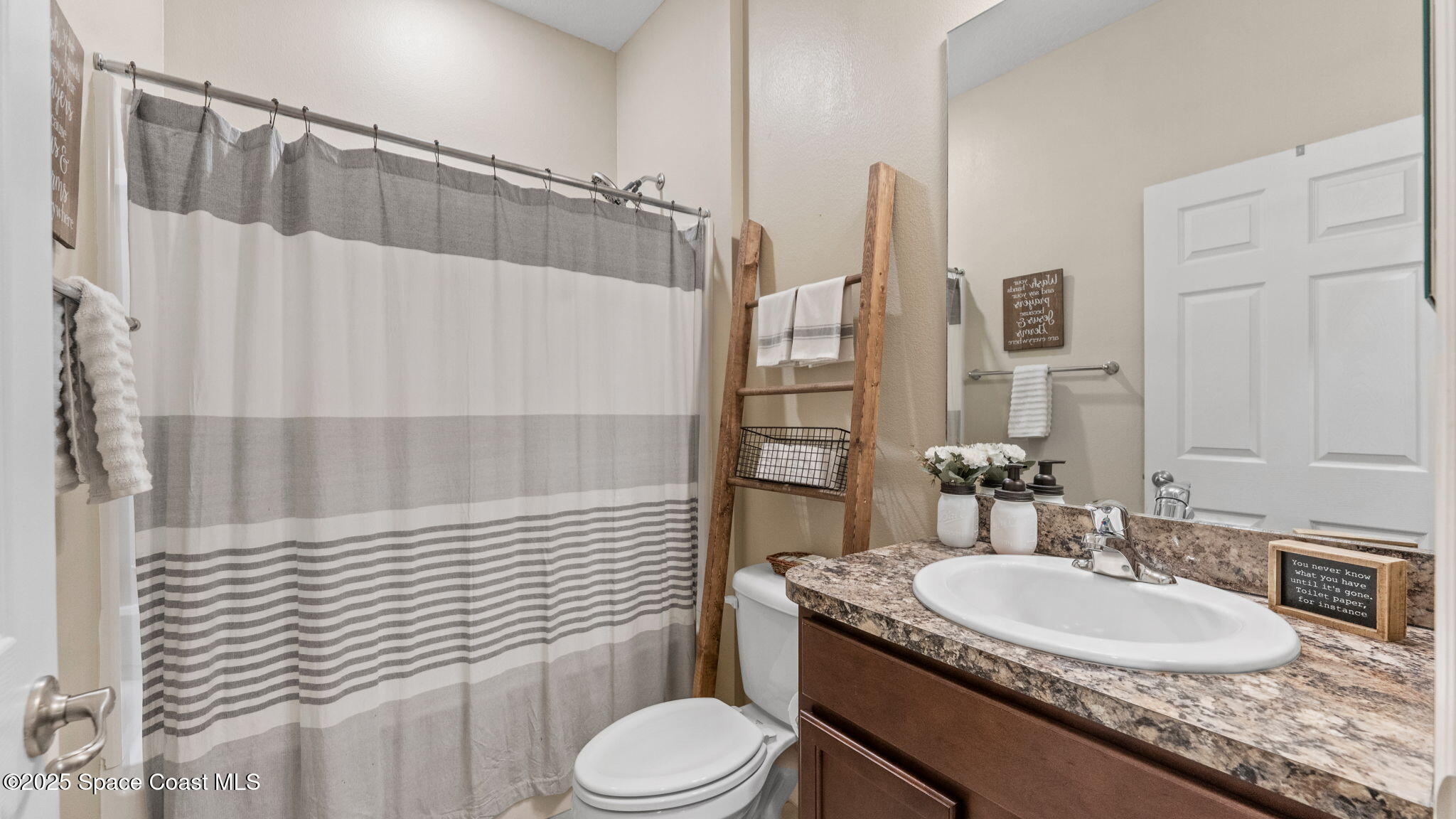 1106 Morgan Circle Northeast Palm Bay, FL 32905 - Photo 34 of 53 a bathroom with a granite countertop sink toilet a mirror and shower