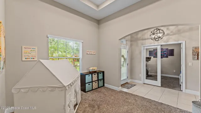 a living room with furniture kitchen view and a chandelier