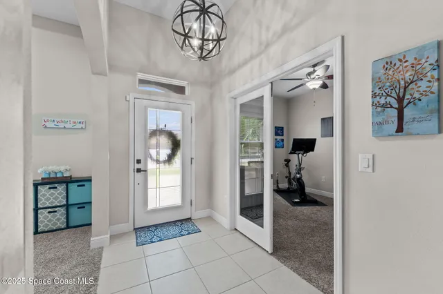 a living room with furniture kitchen view and a chandelier