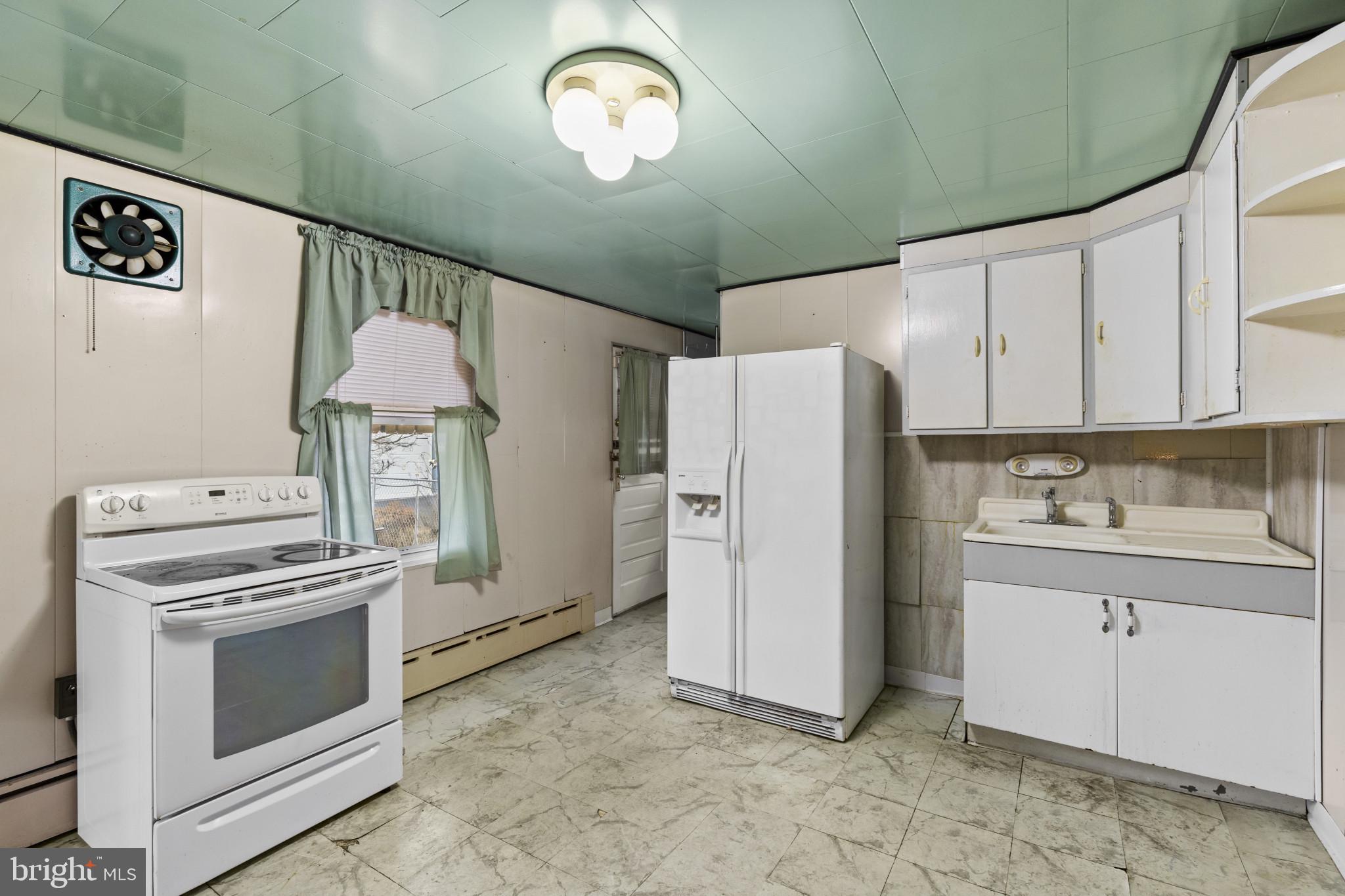 7627 Carson Avenue Baltimore, MD 21224 - Photo 12 of 38 a kitchen with a stove and a refrigerator