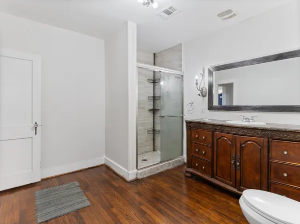 a bathroom with a granite countertop sink toilet and shower