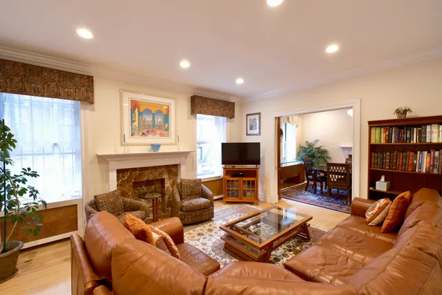 a living room with furniture a bookshelf and a flat screen tv