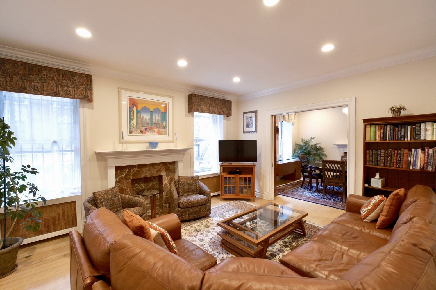 a living room with furniture a bookshelf and a flat screen tv