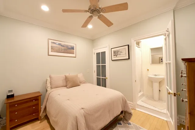 a bedroom with a large bed chandelier and a window