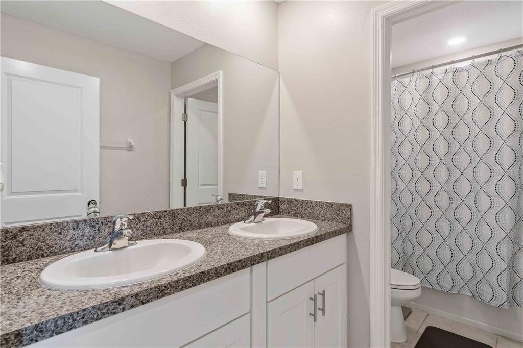 9440 Lemon Drop Loop Sun City Center, FL 33573 - Photo 40 of 55 a bathroom with a granite countertop sink and a mirror