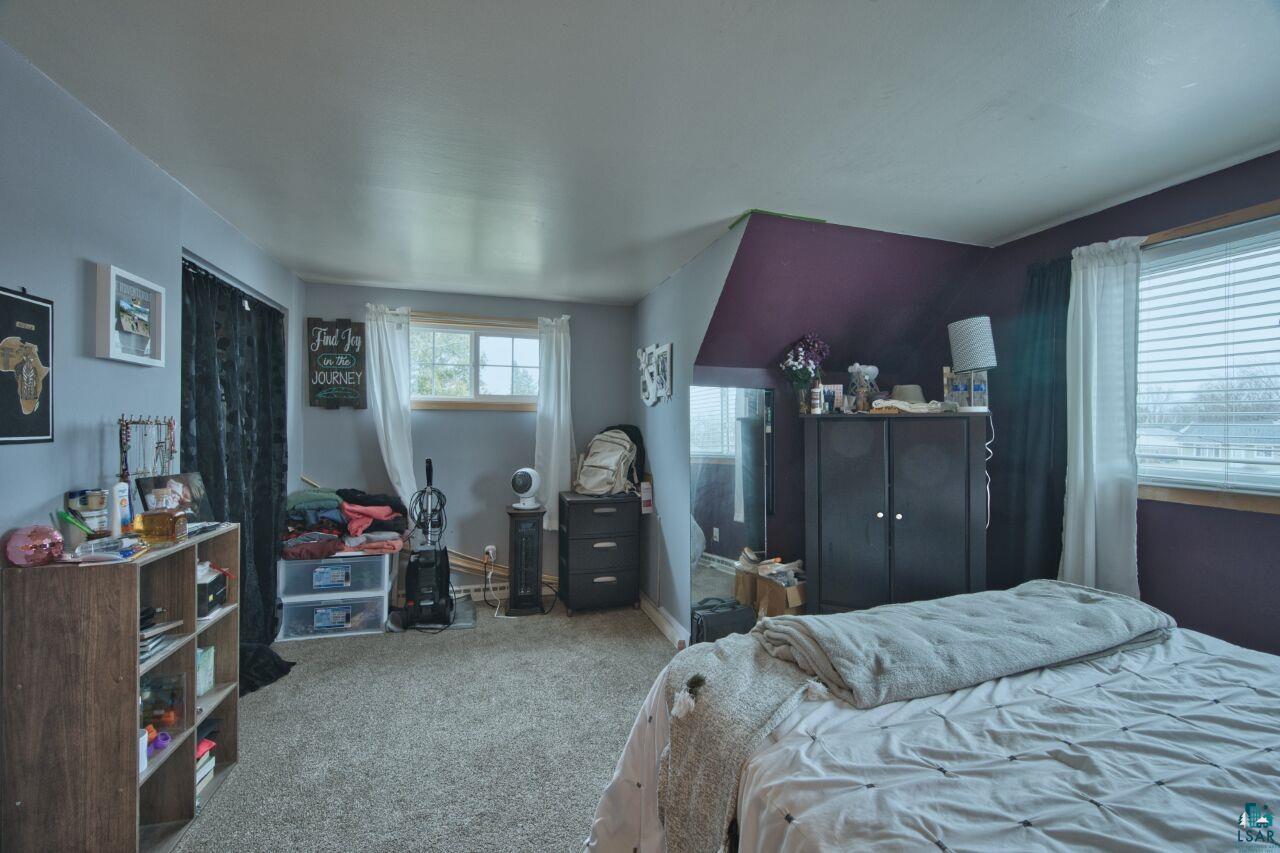 329 Wyandotte Road Hoyt Lakes, MN 55750 - Photo 23 of 52 Carpeted room featuring a window with blinds, a corner wall with a distinct purple accent, and a built-in closet with dark curtains