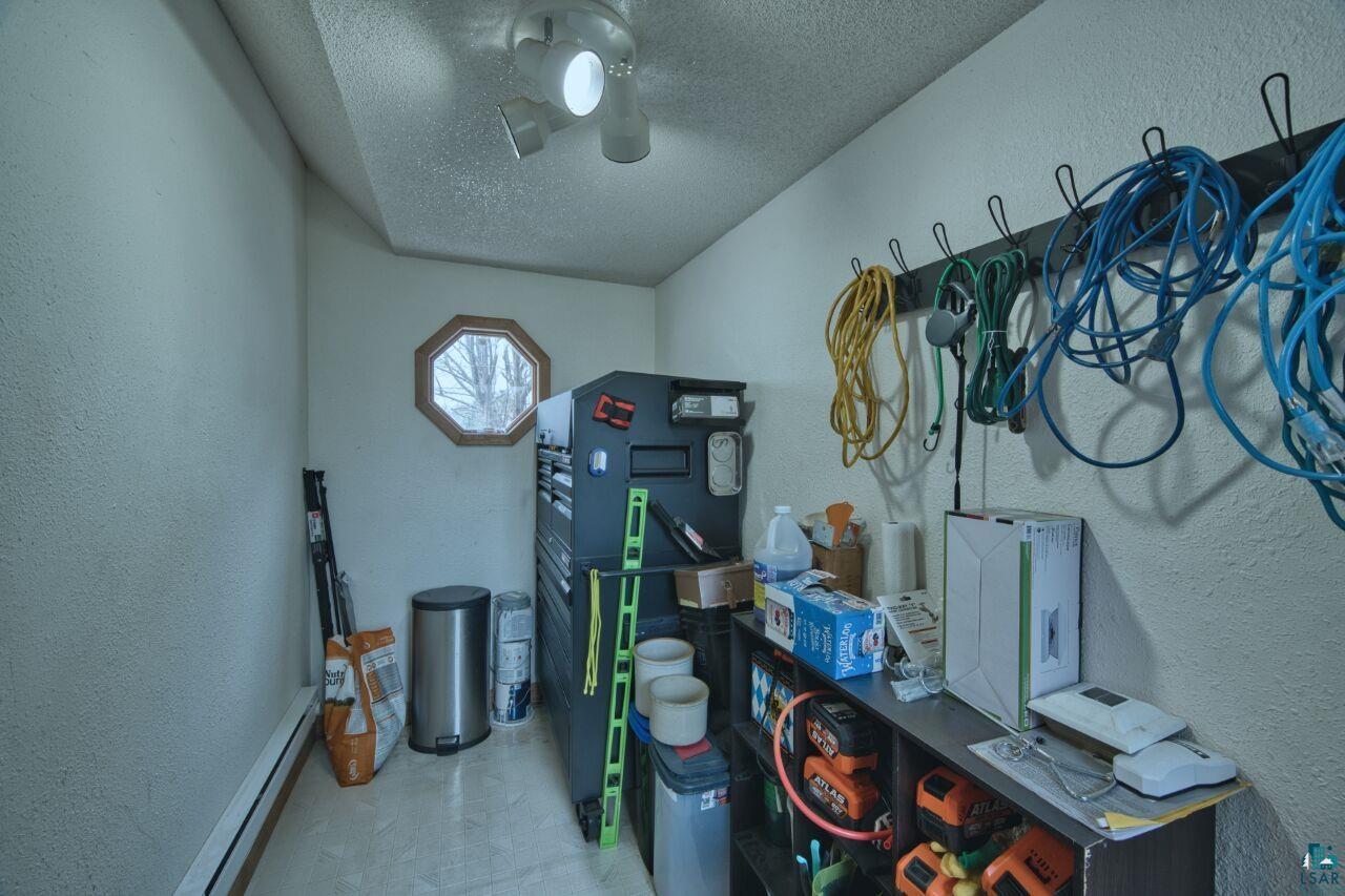 329 Wyandotte Road Hoyt Lakes, MN 55750 - Photo 31 of 52 Utility room featuring an octagon window with wood trim, ceiling-mounted track lighting, and a wall-mounted hook rack